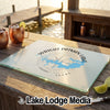 A glass cutting board featuring a blue map of Wright Patman Lake, Texas, rests on a wooden outdoor bar.