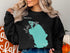 Black sweatshirt with turquoise Lake George, Florida map and compass graphic.