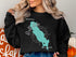 Black sweatshirt featuring a teal outline of Gull Lake, Michigan with compass rose.