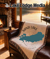 Woven throw blanket featuring a map of Sand Lake, Ontario, on a leather couch.