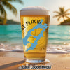 Glass of beer with "Lake Placid" text and blue lake graphic on beach.