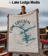 Throw blanket with Lake Greeson Arkansas map design held by a smiling man.