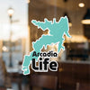 Turquoise sticker of Arcadia Life text with water outline, © Lake Lodge Media LLC.