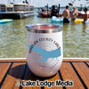 A white travel tumbler with a blue Harlan County Lake map design sitting on a boat deck.