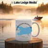 White mug with Manasquan Reservoir map and compass on a lake with boat.