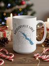 White mug with Saylorville Lake Iowa map and compass graphic, surrounded by holiday decor.