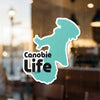 Canobie Life sticker with teal outline on a blurred background.