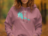 Pink hoodie with turquoise Lake Granby Colorado compass design and subtle autumn background.