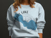 Light blue crewneck sweatshirt with Pearl Lake, Wisconsin map and compass design.