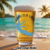 Glass of beer with Kabutla Lake map and compass design on beach.