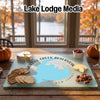 Glass cutting board featuring a map of Merrill Creek Reservoir, New Jersey, surrounded by snacks on a wooden table.