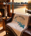 Blanket with Lake Murray map and compass design on a leather couch.