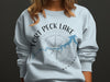 Light blue crewneck sweatshirt with Fort Peck Lake Montana map and compass graphic.