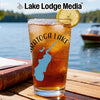 Glass of iced tea with "Saratoga Lake" design and lemon slice, lake background.