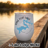 A white travel tumbler with Pine Flat Lake map graphic rests on a wooden dock at sunset.