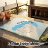 A glass cutting board featuring a Grand Lake, Colorado map graphic resting on a wooden dock with drinks.