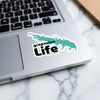 Grapevine Life sticker on laptop keyboard with lake outline and text.