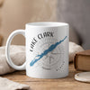White mug with Lake Clark, Alaska map and compass design, steam rising