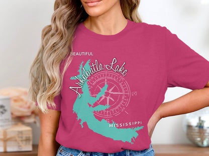 Pink t-shirt featuring a turquoise outline of Arkabutla Lake with compass rose and text.