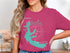 Pink t-shirt featuring a turquoise outline of Arkabutla Lake with compass rose and text.