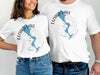 White t-shirts featuring a blue map shape and compass graphic with "Lizard Lake Minnesota" text.