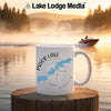 White mug with "Prior Lake Minnesota" and compass design, steaming, on a wooden surface, lake background.