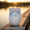 A white stainless steel wine tumbler with Lake Allatoona Georgia graphics sitting on a wooden dock at sunset.