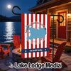 A vertical garden flag hangs on a stand outdoors, featuring red and white stripes, a blue map of Manasquan Reservoir, and the text The Smith Family.