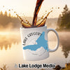 White mug with Lake Gregory California map and compass design, with coffee pouring.
