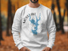 White sweatshirt with blue Moss Lake map on compass rose and text.