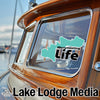 Teal Merrymeeting Life graphic on boat window. Lake Lodge Media text below.