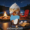 Glass of iced coffee with whipped cream, s'mores ingredients, campfire, and lake at night.