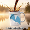 White mug with "Lake Almanor California" design, coffee splashing in.
