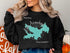 Black sweatshirt with teal Lake Arrowhead map and compass graphic.