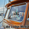 Cayuga Life logo, and "Lake Lodge Media" text on a boat window and hull.