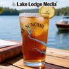 Glass of iced tea with "Lake Sonoma" text and a compass design on a wooden table.