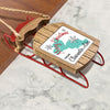 Wooden sled ornament with "Merry Christmas From Clearwater Lake" text and snowflakes.