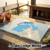 A rectangular glass cutting board featuring a blue map of Floyd Lake, Minnesota, rests on a wooden outdoor bar.