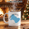 White mug with Lake Calhoun, Georgia map design, in front of fireplace and Christmas tree.