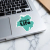Teal sticker with "Moultrie Life" text on a laptop keyboard.
