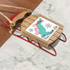 Red metal sled ornament with wooden deck reading "Merry Christmas From Ross Barnett Lake".