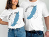 White t-shirts with a blue map of Carlyle Lake, Illinois, and compass graphic.