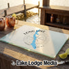 A rectangular glass cutting board with a blue Long Lake Maine design rests on a wooden outdoor bar.