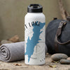 White water bottle with blue lake map and compass graphic, next to a rolled towel and duffel bag.