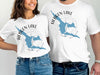 White t-shirts with blue Hebgen Lake map and compass graphic.