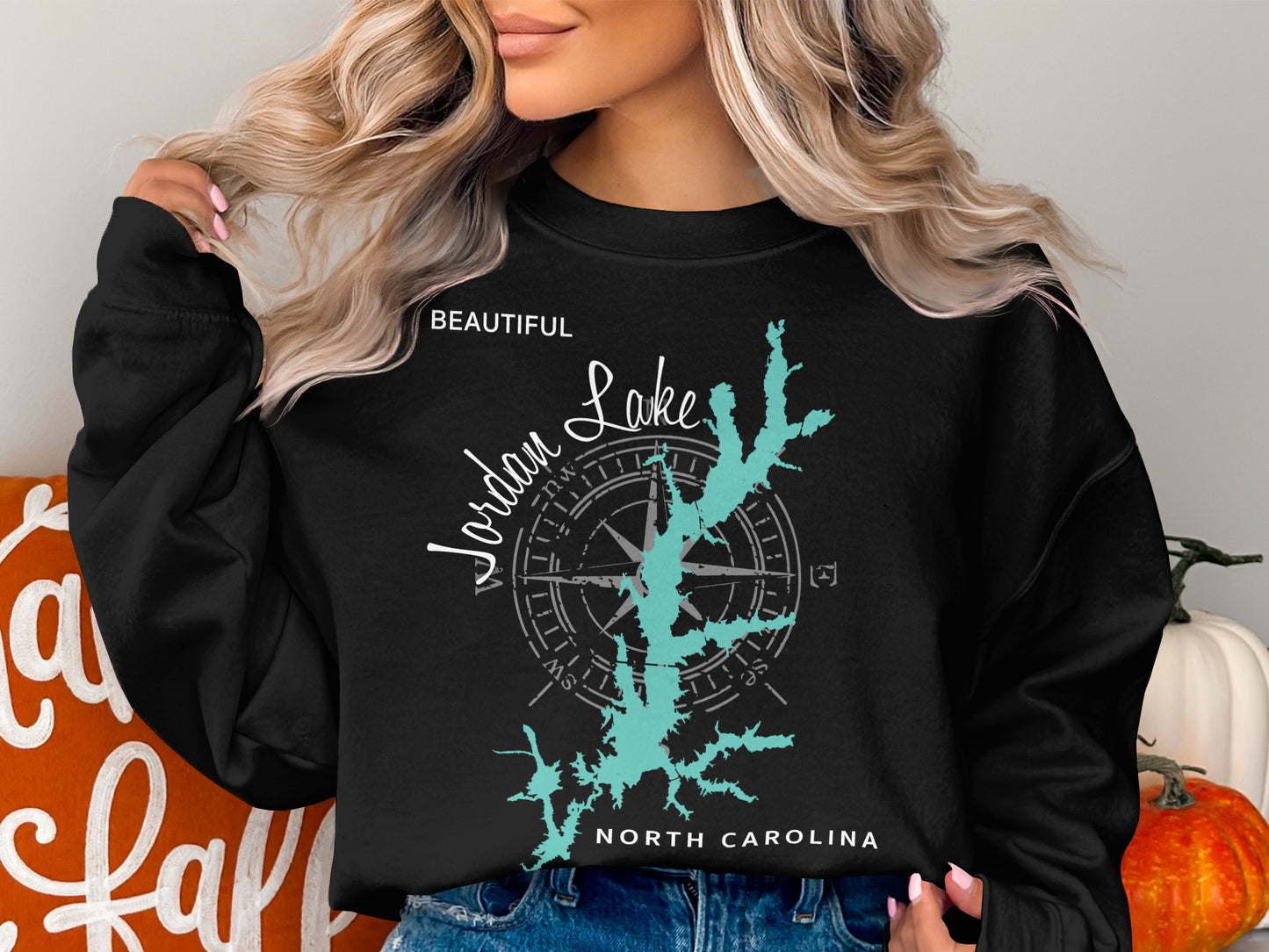 Black sweatshirt with turquoise Jordan Lake map and compass rose graphic.