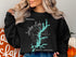 Black sweatshirt with turquoise Jordan Lake map and compass rose graphic.