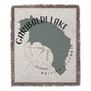 Woven blanket with Garibaldi Lake shape, compass rose, and text.