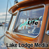 Icaria Life sticker on a wooden boat with "Lake Lodge Media" text below.