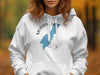 White hoodie with Moraine Lake Alberta map graphic and compass design.